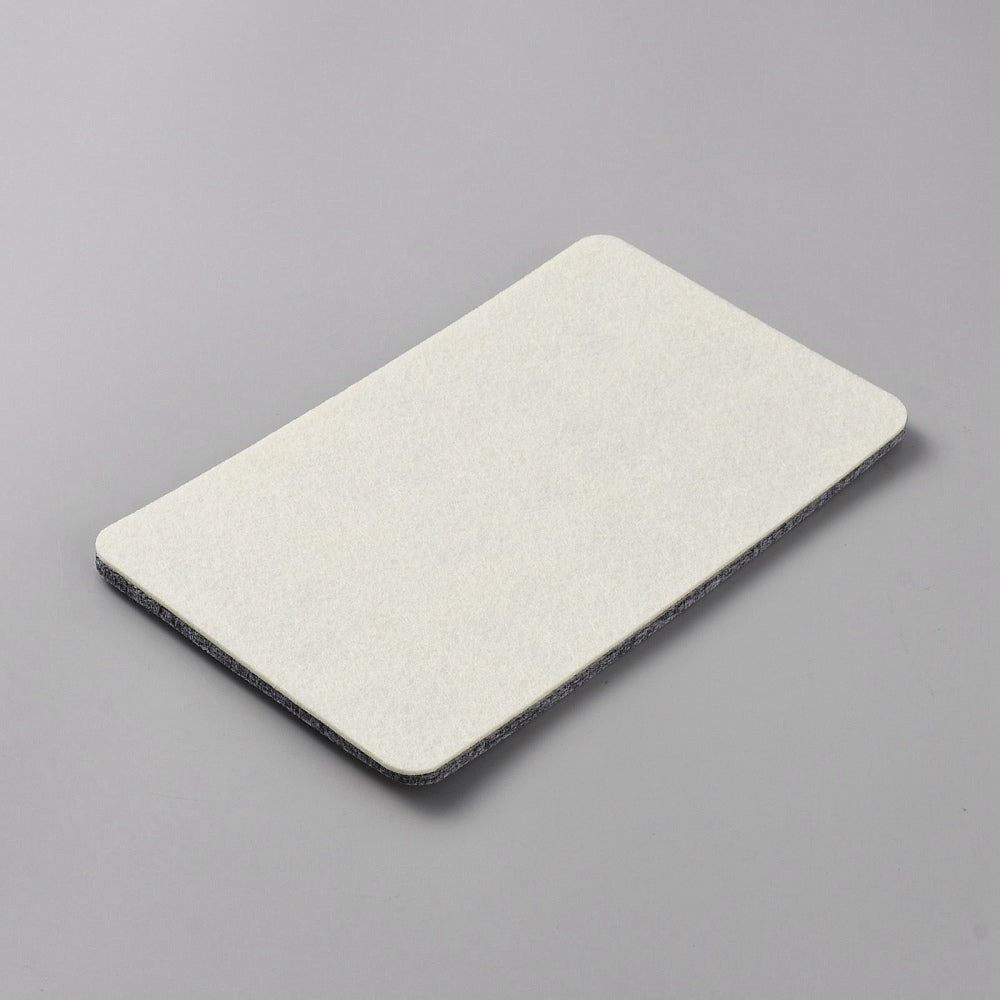 Baksidan av pärlplatta i filt för smyckestillverkning med rutor från A till U för att sortera pärlor.