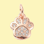 Tassavtrycksformad berlock med mikroinfattade cubic zirconia i roséguldfärg.